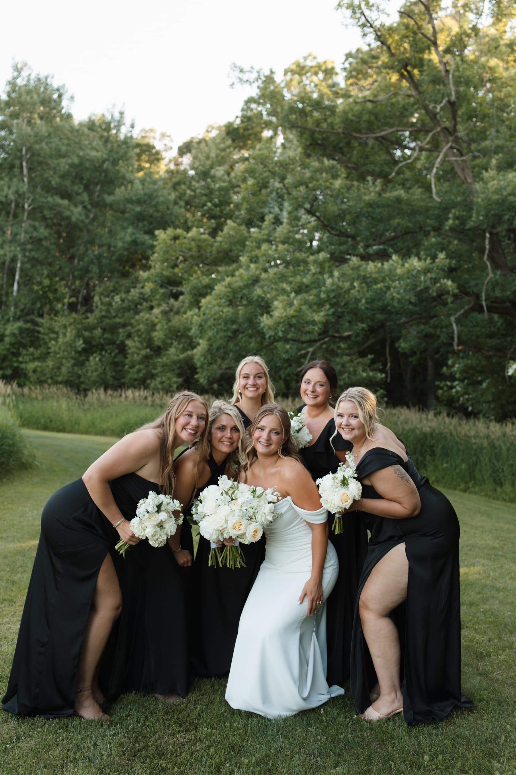 Bridesmaids in black gathered around the bride